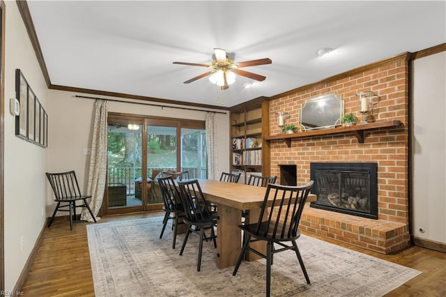 6 Hastings Ln, Williamsburg, VA 23188 - dining room featuring baseboards, ornamental molding, a ceiling fan, a brick fireplace, and wood finished floors