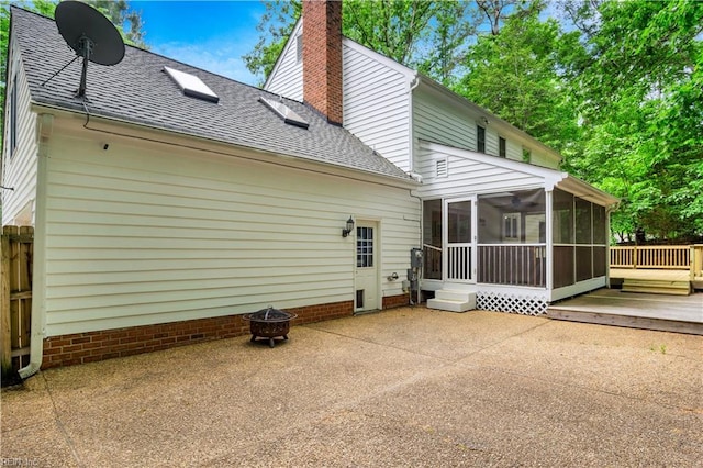 6 Hastings Ln, Williamsburg, VA 23188 - back of house featuring roof with shingles, a sunroom, an outdoor fire pit, a chimney, and a patio