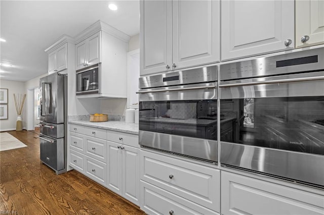 kitchen featuring stainless steel appliances, white cabinets, recessed lighting, dark wood-style flooring, and light stone countertops