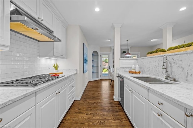 kitchen featuring a sink, under cabinet range hood, appliances with stainless steel finishes, decorative backsplash, and white cabinetry
