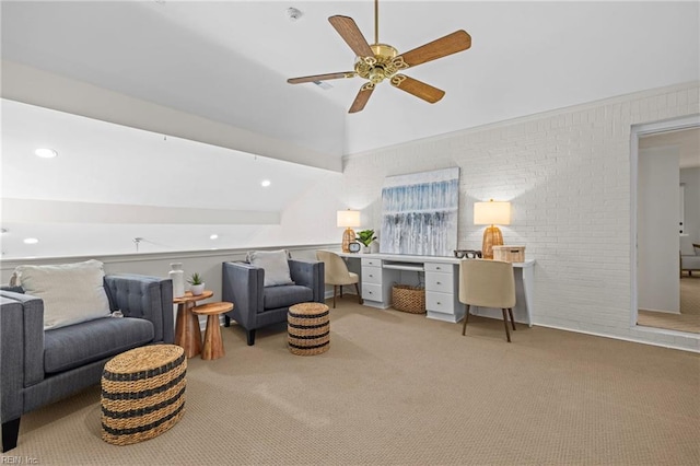 sitting room featuring carpet, ceiling fan, brick wall, lofted ceiling, and a desk