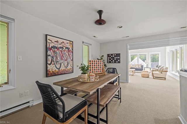 dining space featuring a baseboard heating unit, carpet flooring, and baseboards