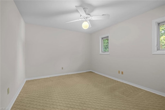 empty room featuring plenty of natural light, light carpet, and baseboards