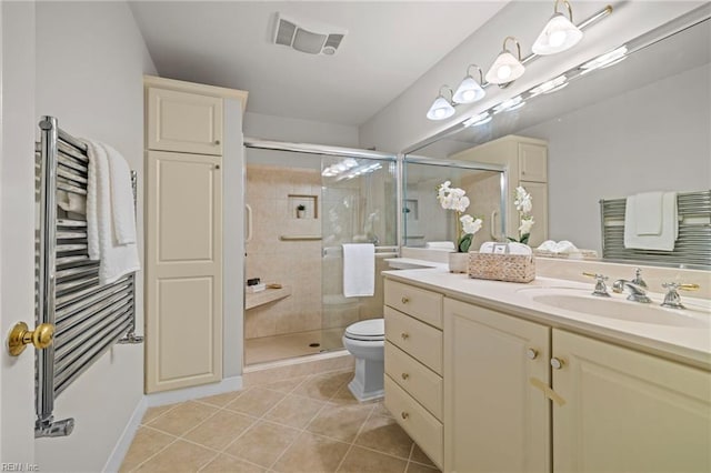 bathroom featuring radiator, tile patterned floors, a stall shower, vanity, and toilet
