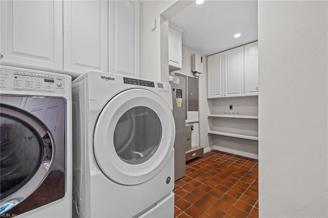 laundry room featuring washing machine and dryer, cabinet space, recessed lighting, and dark tile patterned floors