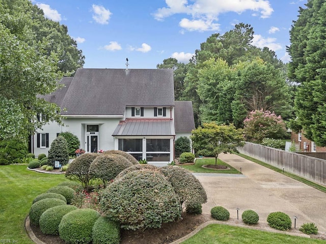 rear view of property featuring a sunroom, stucco siding, and a shingled roof
