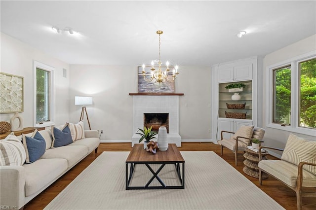living area with healthy amount of natural light, a chandelier, and baseboards