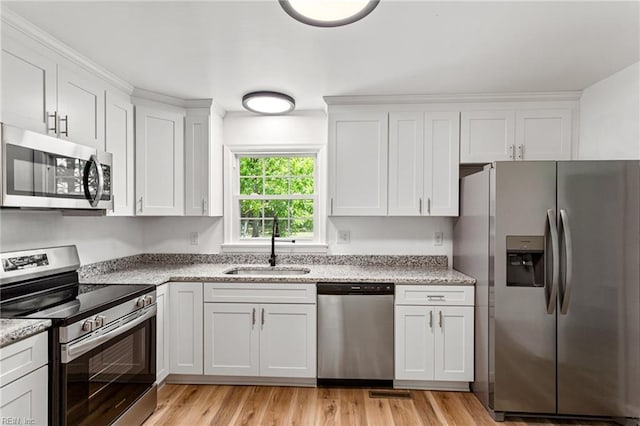 7709 S Quay Rd, Suffolk, VA 23437 - kitchen featuring appliances with stainless steel finishes, a sink, white cabinets, and light wood-style floors
