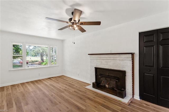 7709 S Quay Rd, Suffolk, VA 23437 - unfurnished living room featuring a ceiling fan, baseboards, wood finished floors, and a brick fireplace