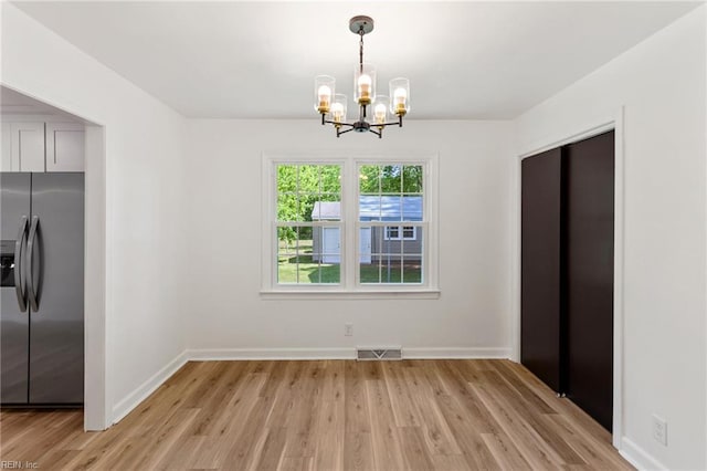 7709 S Quay Rd, Suffolk, VA 23437 - unfurnished dining area featuring a chandelier, baseboards, and light wood-style flooring