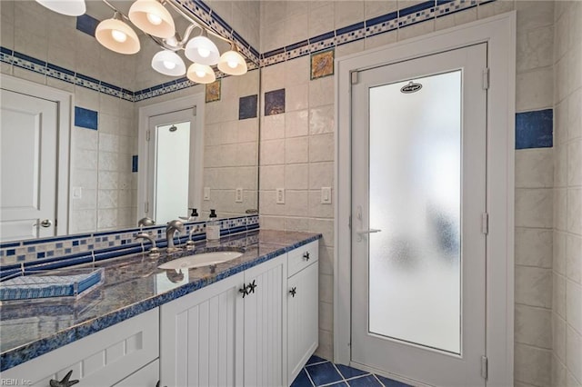 bathroom featuring tile walls, vanity, tile patterned flooring, and backsplash