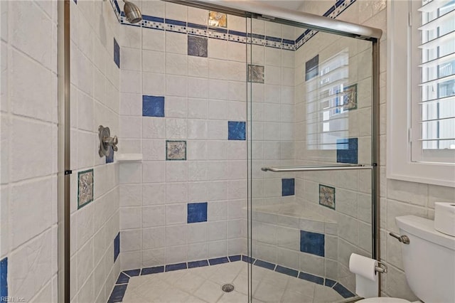 bathroom featuring toilet and a shower stall