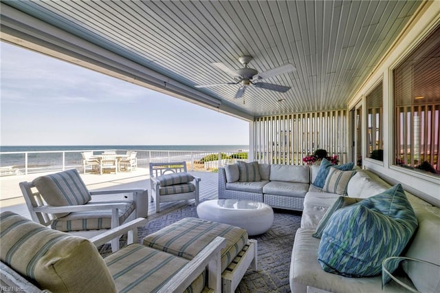 view of patio featuring view of water and beach, outdoor lounge area, and ceiling fan