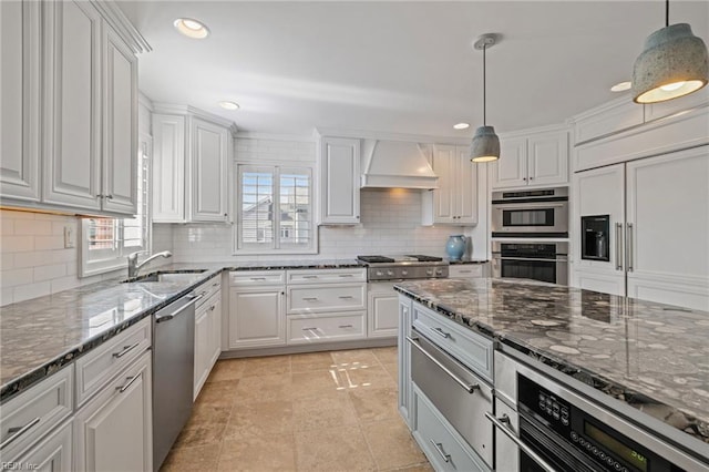 kitchen featuring a sink, custom range hood, stainless steel appliances, white cabinetry, and recessed lighting