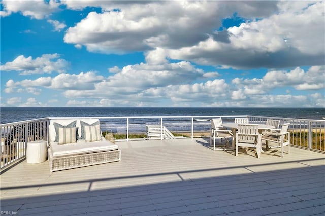 wooden terrace with a water view and outdoor dining space