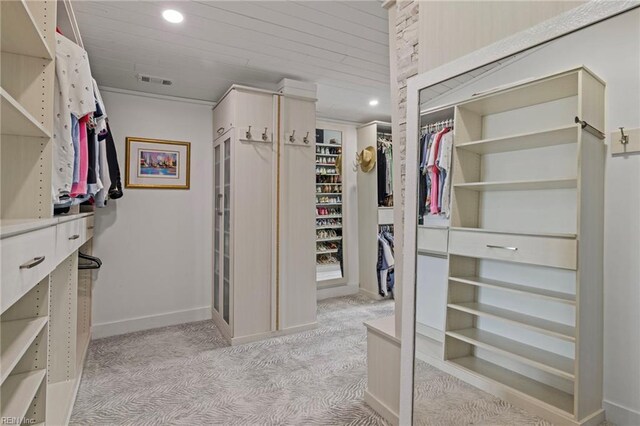 spacious closet featuring light colored carpet