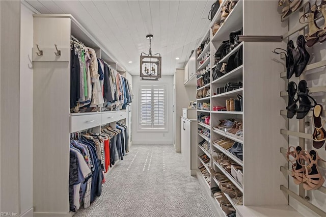 walk in closet with light colored carpet