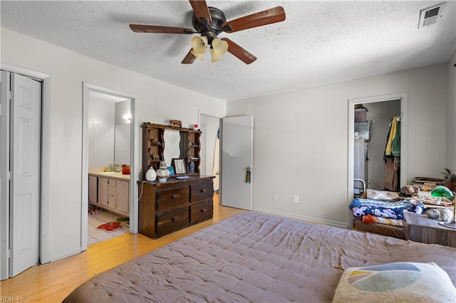3667 Smokey Chamber Dr, Virginia Beach, VA 23462 - bedroom with light wood-type flooring, a textured ceiling, a closet, ensuite bathroom, and ceiling fan