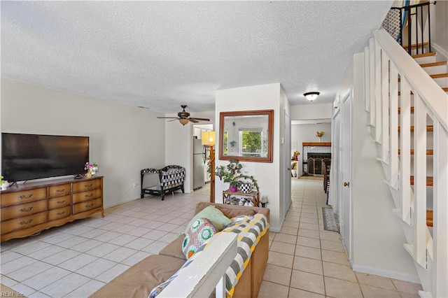 3667 Smokey Chamber Dr, Virginia Beach, VA 23462 - living area featuring light tile patterned floors, stairs, a textured ceiling, a ceiling fan, and a fireplace with raised hearth