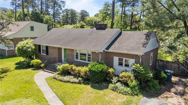 view of front of house featuring brick siding, a chimney, and a shingled roof
