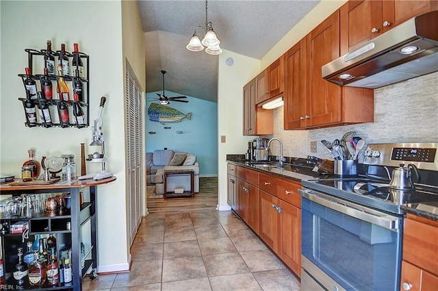 kitchen featuring stainless steel electric range oven, under cabinet range hood, lofted ceiling, ceiling fan, and a sink