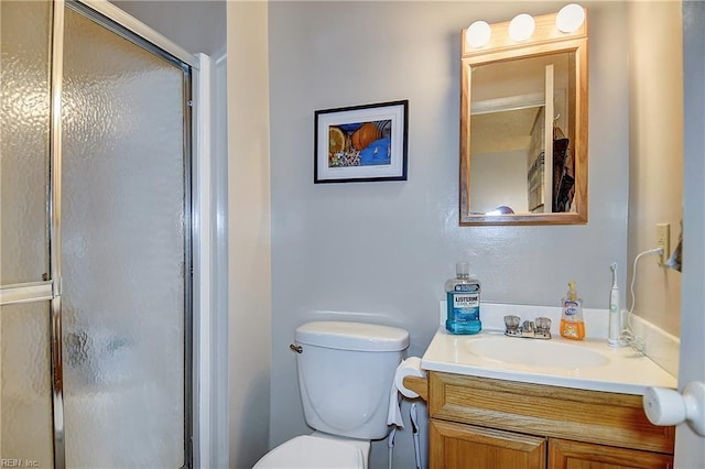 bathroom with a shower stall, vanity, and toilet