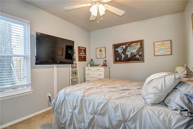 carpeted bedroom featuring multiple windows, a ceiling fan, and baseboards