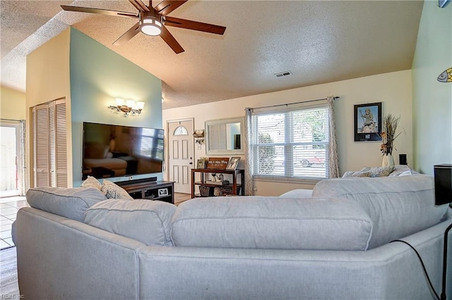 living room with a textured ceiling, lofted ceiling, and a ceiling fan
