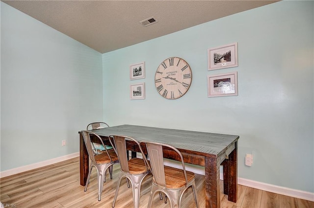 dining space with baseboards and wood finished floors