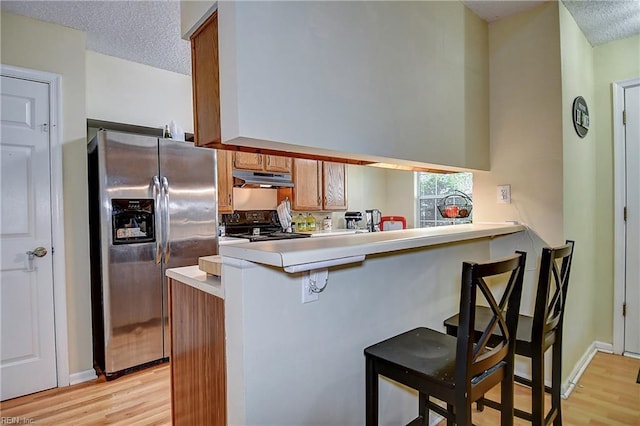841 Masters Trl, Newport News, VA 23602 - kitchen featuring stainless steel refrigerator with ice dispenser, under cabinet range hood, black electric range, light wood-style flooring, and light countertops
