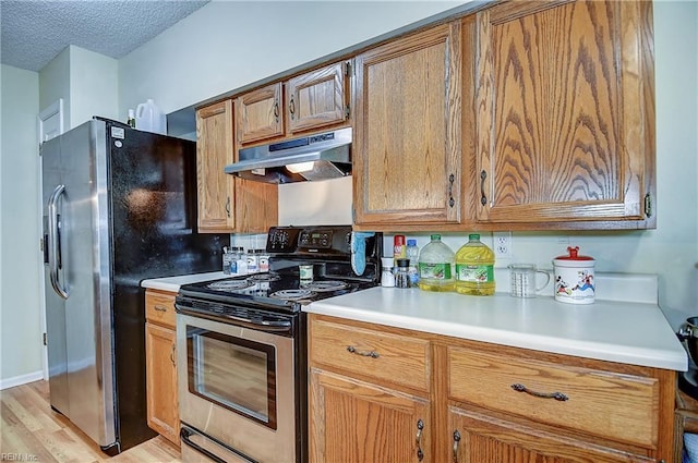841 Masters Trl, Newport News, VA 23602 - kitchen featuring under cabinet range hood, stainless steel appliances, light countertops, light wood finished floors, and a textured ceiling