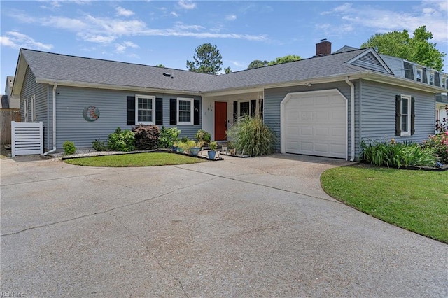 view of front of home with concrete driveway, an attached garage, a chimney, a shingled roof, and a front yard