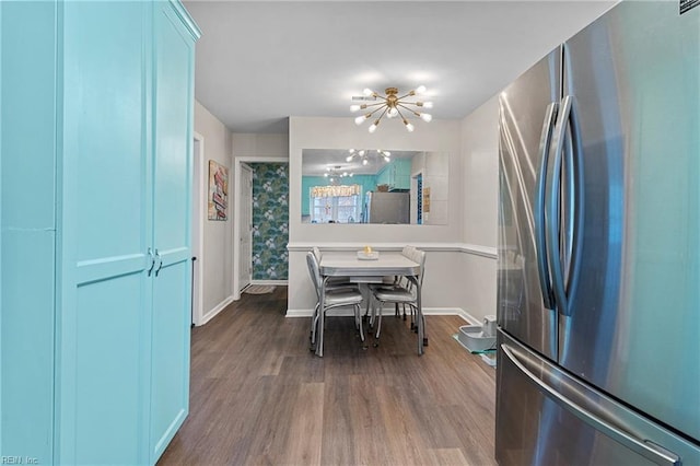 dining space featuring a chandelier, dark wood-style floors, and baseboards