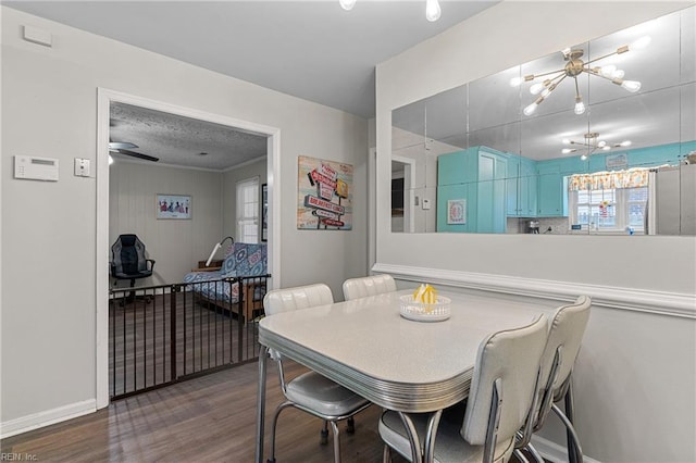 dining space with wood finished floors, a chandelier, and baseboards