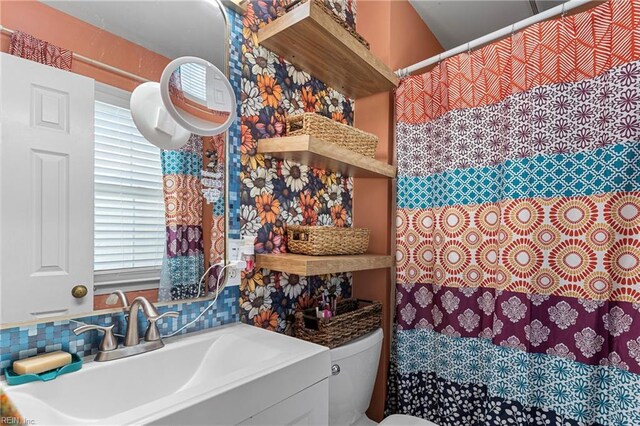 bathroom featuring toilet, a shower with shower curtain, plenty of natural light, and vanity