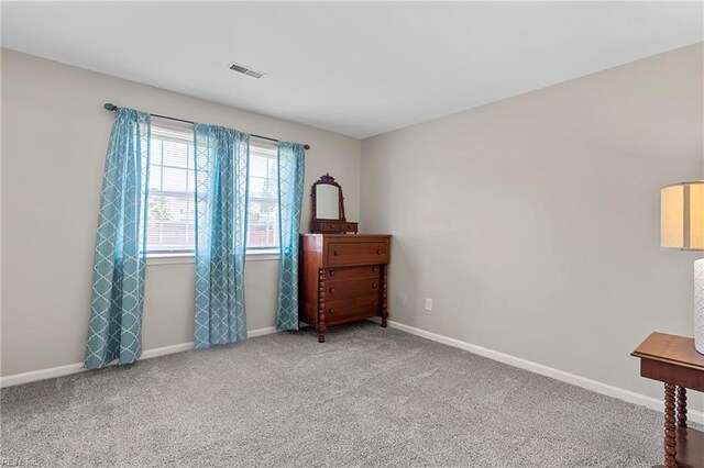 carpeted spare room featuring baseboards