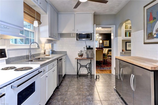 21 Westover Rd, Newport News, VA 23601 - kitchen featuring stainless steel appliances, a sink, ceiling fan, decorative backsplash, and tile walls