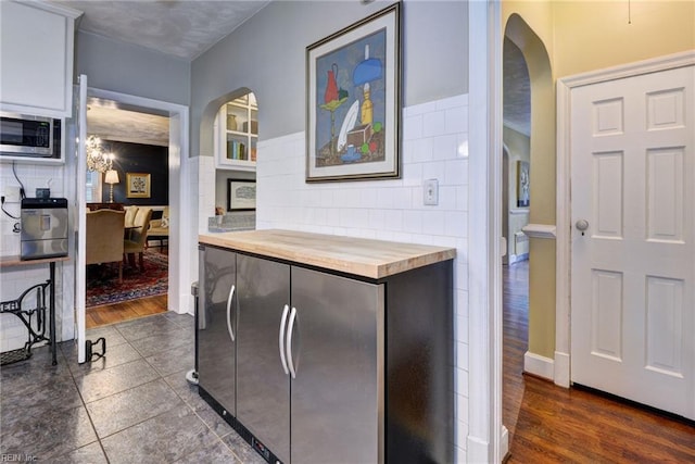 21 Westover Rd, Newport News, VA 23601 - kitchen with wood counters, arched walkways, stainless steel microwave, dark wood-style flooring, and tile walls