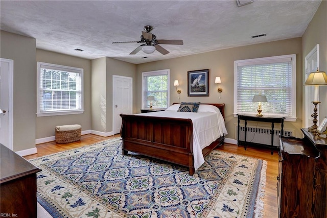 21 Westover Rd, Newport News, VA 23601 - bedroom featuring radiator heating unit, multiple windows, baseboards, wood finished floors, and a textured ceiling