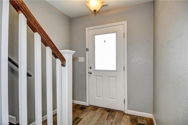 entrance foyer featuring wood finished floors, baseboards, and stairway