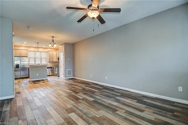 unfurnished living room with wood finished floors, baseboards, a ceiling fan, a chandelier, and recessed lighting
