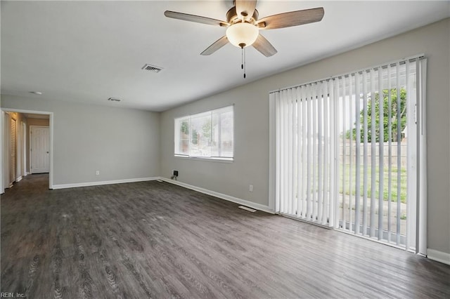 spare room featuring dark wood-style floors, baseboards, and ceiling fan