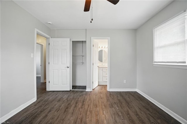 unfurnished bedroom with dark wood-type flooring, baseboards, a ceiling fan, and ensuite bathroom