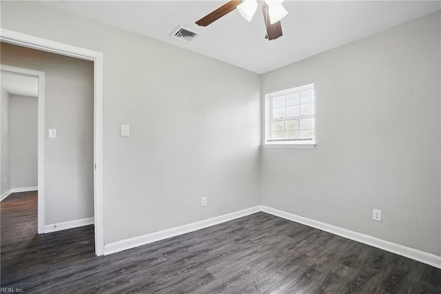 empty room featuring ceiling fan, dark wood finished floors, and baseboards