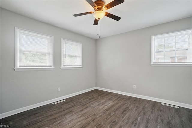 unfurnished room with dark wood finished floors, baseboards, and a ceiling fan