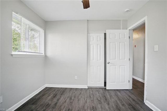 unfurnished bedroom featuring dark wood-style floors, baseboards, a closet, and ceiling fan