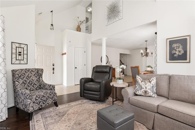 3009 Hogan Way, Suffolk, VA 23435 - living area featuring wood finished floors, a chandelier, decorative columns, and high vaulted ceiling