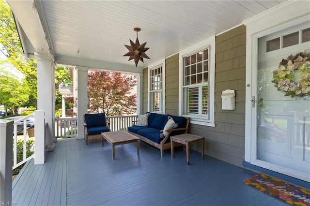 wooden terrace with a porch, an outdoor living space, and ceiling fan