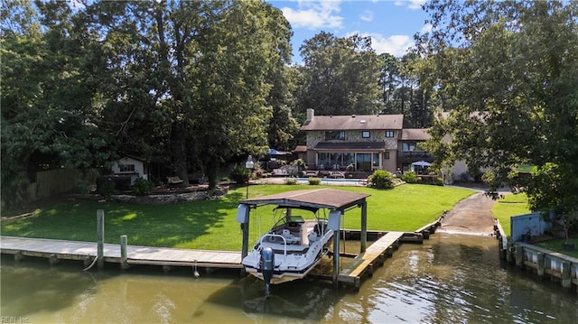 dock area with a water view, a yard, and boat lift