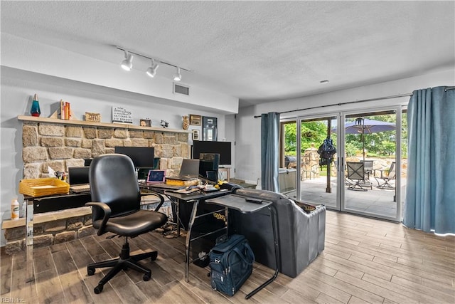 office space with wood finished floors, a textured ceiling, and rail lighting